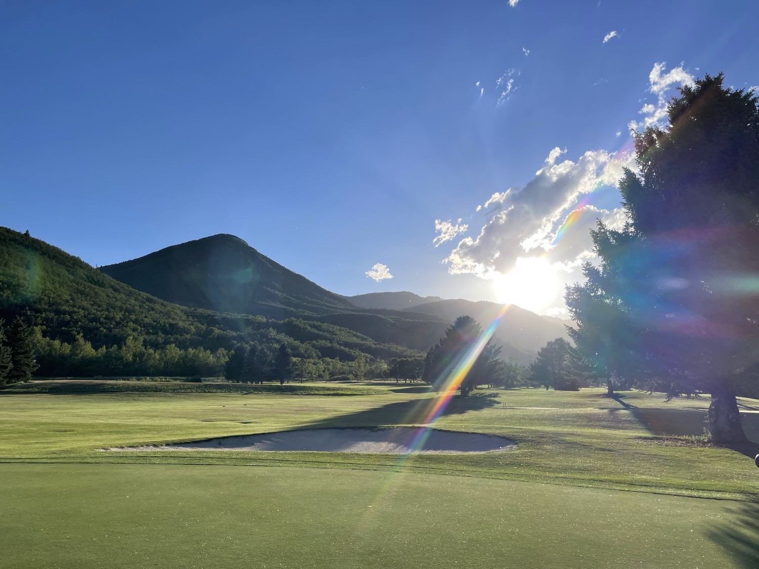 Fairway, bunker, and mountain light on a golf course
